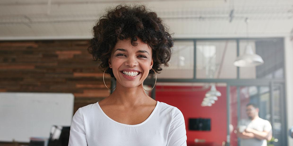 Woman smiling wearing large gold hoop earrings